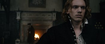 Movie still from “Anonymous” (2011), directed by Roland Emmerich – A man standing in front of a fire place; Close Up shot, Over the shoulder angle