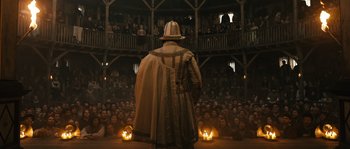 Movie still from “Anonymous” (2011), directed by Roland Emmerich – A crowd of people are watching a man in a hat; Wide shot, Low angle