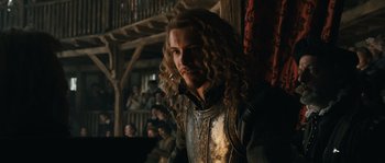 Movie still from “Anonymous” (2011), directed by Roland Emmerich – A person with long curly hair; Medium shot, Over the shoulder angle