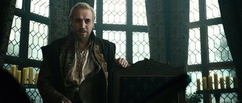 Movie still from “Anonymous” (2011), directed by Roland Emmerich – A man sitting on a chair in a room; Medium shot, Over the shoulder angle