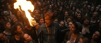 Movie still from “Anonymous” (2011), directed by Roland Emmerich – A crowd of people gathered around a man with a mask on his head; Medium shot, High angle