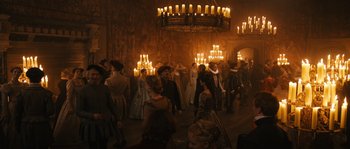 Movie still from “Anonymous” (2011), directed by Roland Emmerich – A group of people standing in a room with lit candles; Wide shot, High angle