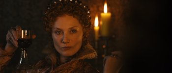 Movie still from “Anonymous” (2011), directed by Roland Emmerich – A person wearing a crown near candles; Close Up shot, Low angle