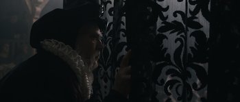 Movie still from “Anonymous” (2011), directed by Roland Emmerich – A woman in a black hat and a black and white curtain; Close Up shot, Over the shoulder angle