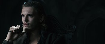 Movie still from “Anonymous” (2011), directed by Roland Emmerich – A man with long blonde hair is sitting in the dark; Close Up shot, High angle