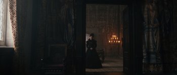 Movie still from “Anonymous” (2011), directed by Roland Emmerich – A woman sitting in a chair in a dark room; Wide shot, Over the shoulder angle