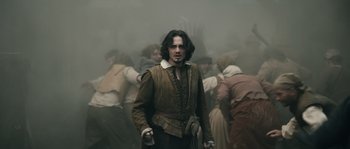 Movie still from “Anonymous” (2011), directed by Roland Emmerich – A man standing in the middle of a group of people; Medium shot, Over the shoulder angle