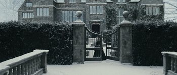 Movie still from “Anonymous” (2011), directed by Roland Emmerich – A woman standing in a gated entrance to a house; Extreme Wide shot, High angle