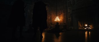Movie still from “Anonymous” (2011), directed by Roland Emmerich – A group of people sitting in a room with candles lit up; Wide shot, Low angle