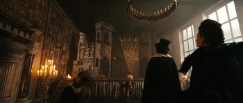 Movie still from “Anonymous” (2011), directed by Roland Emmerich – A man in a black cape stands in front of a castle; Extreme Wide shot, High angle