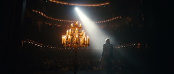 Movie still from “Anonymous” (2011), directed by Roland Emmerich – A man standing in front of a chandelier in the middle of an audience; Extreme Wide shot, Low angle
