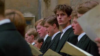 Movie still from “Another Country” (1984), directed by Marek Kanievska – A group of young men in business suits singing; Close Up shot, Low angle