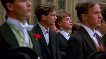Movie still from “Another Country” (1984), directed by Marek Kanievska – A group of men in suits and ties standing next to each other; Medium shot, Low angle