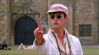 Movie still from “Another Country” (1984), directed by Marek Kanievska – A man in a hat and sunglasses pointing to the side; Close Up shot, Low angle