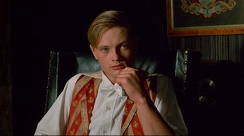 Movie still from “Another Country” (1984), directed by Marek Kanievska – A man sitting in a chair with his hand under his chin; Close Up shot, Low angle
