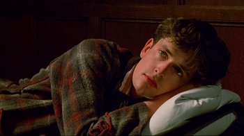 Movie still from “Another Country” (1984), directed by Marek Kanievska – A man laying on a bed in a room; Close Up shot, High angle