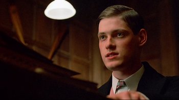 Movie still from “Another Country” (1984), directed by Marek Kanievska – A man in a suit and tie looking at the camera; Close Up shot, Low angle