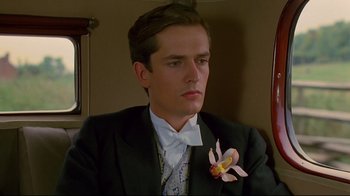 Movie still from “Another Country” (1984), directed by Marek Kanievska – A man in a suit and tie with a flower in his lapel; Close Up shot, Low angle