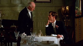 Movie still from “Another Country” (1984), directed by Marek Kanievska – Two men in suits sitting at a dinner table; Medium shot, Over the shoulder angle