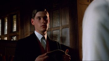 Movie still from “Another Country” (1984), directed by Marek Kanievska – A man in a suit and tie holding onto a rope; Close Up shot, Low angle