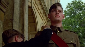 Movie still from “Another Country” (1984), directed by Marek Kanievska – A young man in a military uniform adjusting his tie; Close Up shot, Low angle