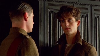 Movie still from “Another Country” (1984), directed by Marek Kanievska – A man in a brown jacket looking at another man in a brown jacket; Close Up shot, Over the shoulder angle