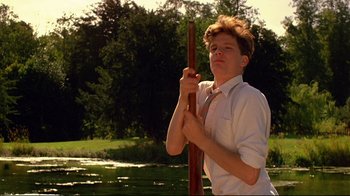 Movie still from “Another Country” (1984), directed by Marek Kanievska – A young man holding a wooden stick in his hands; Medium shot, Low angle