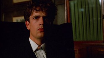Movie still from “Another Country” (1984), directed by Marek Kanievska – A man in a suit and tie looking into a mirror; Close Up shot, Low angle