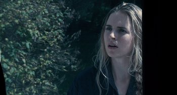 Movie still from “Another Earth” (2011), directed by Mike Cahill – A woman with long blonde hair standing next to a tree; Close Up shot, Over the shoulder angle