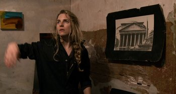 Movie still from “Another Earth” (2011), directed by Mike Cahill – A woman standing in front of a picture of a building; Close Up shot, Over the shoulder angle