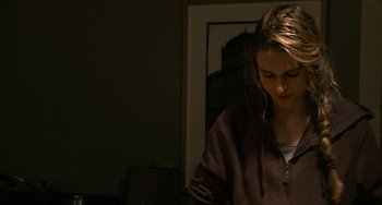 Movie still from “Another Earth” (2011), directed by Mike Cahill – A woman standing in a room looking down at the floor; Close Up shot, Over the shoulder angle