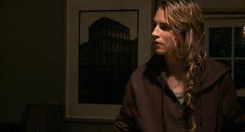 Movie still from “Another Earth” (2011), directed by Mike Cahill – A woman standing in front of a picture of a building; Close Up shot, Over the shoulder angle