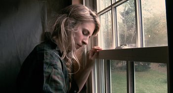 Movie still from “Another Earth” (2011), directed by Mike Cahill – A woman sitting in front of a window looking sad; Close Up shot, High angle