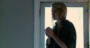 Movie still from “Another Earth” (2011), directed by Mike Cahill – A woman standing in front of an open window; Close Up shot, Over the shoulder angle