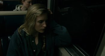 Movie still from “Another Earth” (2011), directed by Mike Cahill – A woman sitting on a train with her head resting on her hand; Close Up shot, High angle