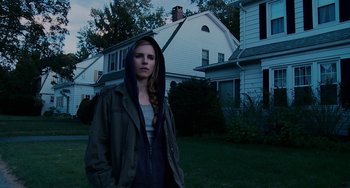 Movie still from “Another Earth” (2011), directed by Mike Cahill – A young woman standing in front of a white house; Medium shot, Low angle