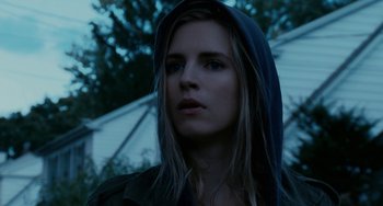 Movie still from “Another Earth” (2011), directed by Mike Cahill – A young woman with a hooded jacket looking at the camera; Close Up shot, Low angle