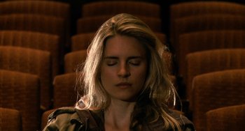 Movie still from “Another Earth” (2011), directed by Mike Cahill – A woman sitting in front of a row of seats; Close Up shot, High angle