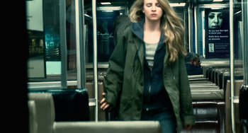 Movie still from “Another Earth” (2011), directed by Mike Cahill – A woman is walking on a train with a suitcase; Medium shot, Over the shoulder angle
