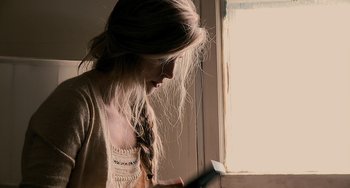 Movie still from “Another Earth” (2011), directed by Mike Cahill – A woman with long blonde hair looking out of a window; Close Up shot, Over the shoulder angle
