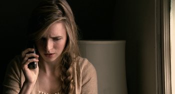 Movie still from “Another Earth” (2011), directed by Mike Cahill – A woman sitting in front of a lamp looking sad; Close Up shot, Over the shoulder angle