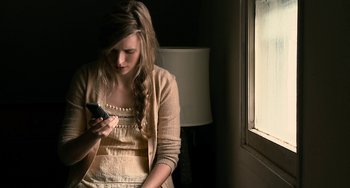Movie still from “Another Earth” (2011), directed by Mike Cahill – A woman is looking at her cell phone; Close Up shot, High angle