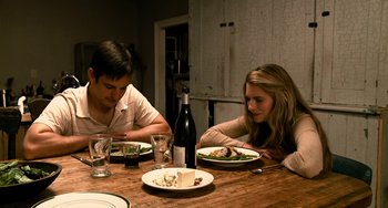 Movie still from “Another Earth” (2011), directed by Mike Cahill – A man and a woman sitting at a table with plates of food; Medium shot, Low angle
