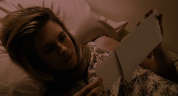 Movie still from “Another Earth” (2011), directed by Mike Cahill – A woman is reading a book while laying in a bed; Close Up shot, High angle