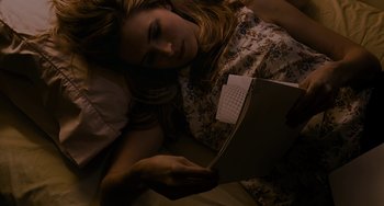 Movie still from “Another Earth” (2011), directed by Mike Cahill – A woman laying in a bed with a laptop; Close Up shot, High angle