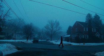 Movie still from “Another Earth” (2011), directed by Mike Cahill – A person is walking down the street on a snowy day; Extreme Wide shot, Low angle