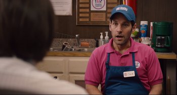Movie still from “Ant-Man” (2015), directed by Peyton Reed – A man wearing a pink shirt and a blue hat talking to a woman; Medium shot, Over the shoulder angle