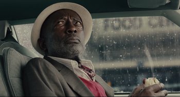 Movie still from “Ant-Man” (2015), directed by Peyton Reed – An older man wearing a white hat sitting in the driver's seat of a car; Close Up shot, Low angle