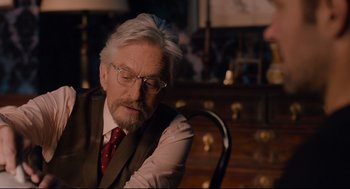 Movie still from “Ant-Man” (2015), directed by Peyton Reed – An older man sitting in a chair in front of a desk; Close Up shot, Over the shoulder angle