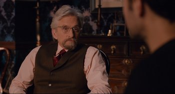 Movie still from “Ant-Man” (2015), directed by Peyton Reed – An older man wearing a suit and tie; Close Up shot, Over the shoulder angle